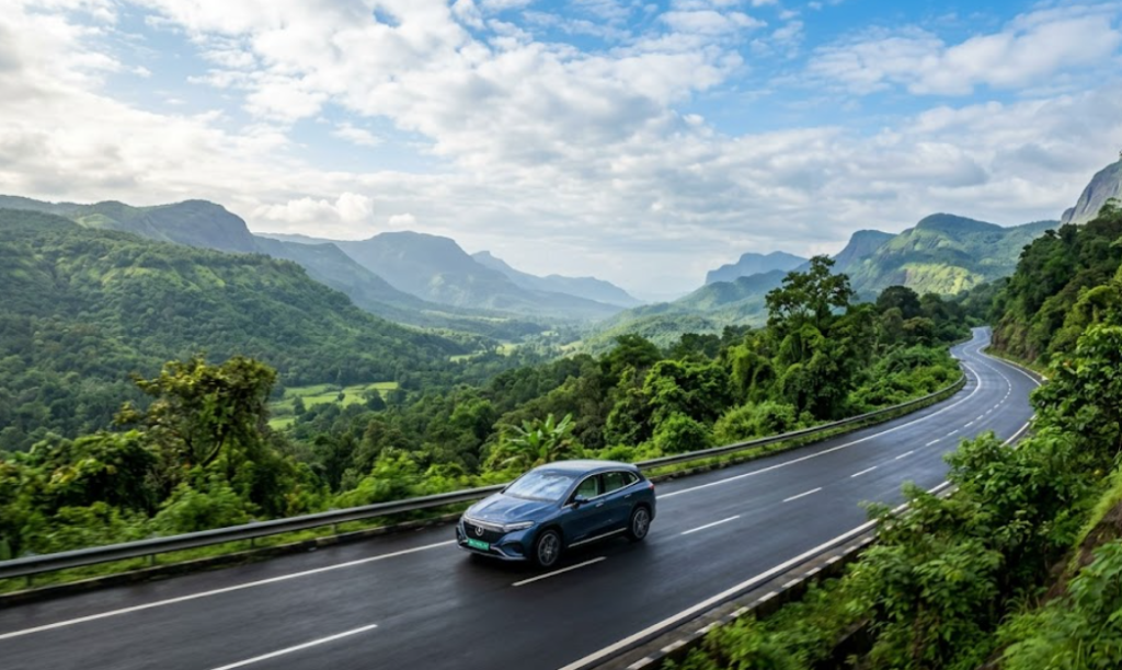 A white electric SUV driving on a scenic highway in the Western Ghats India.